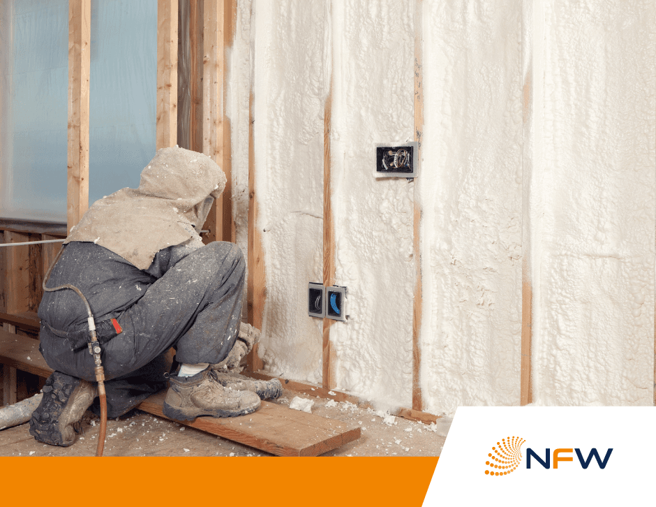 Spray foam applied to a commercial stud wall Technician in coveralls spraying foam insulation onto a full stud wall