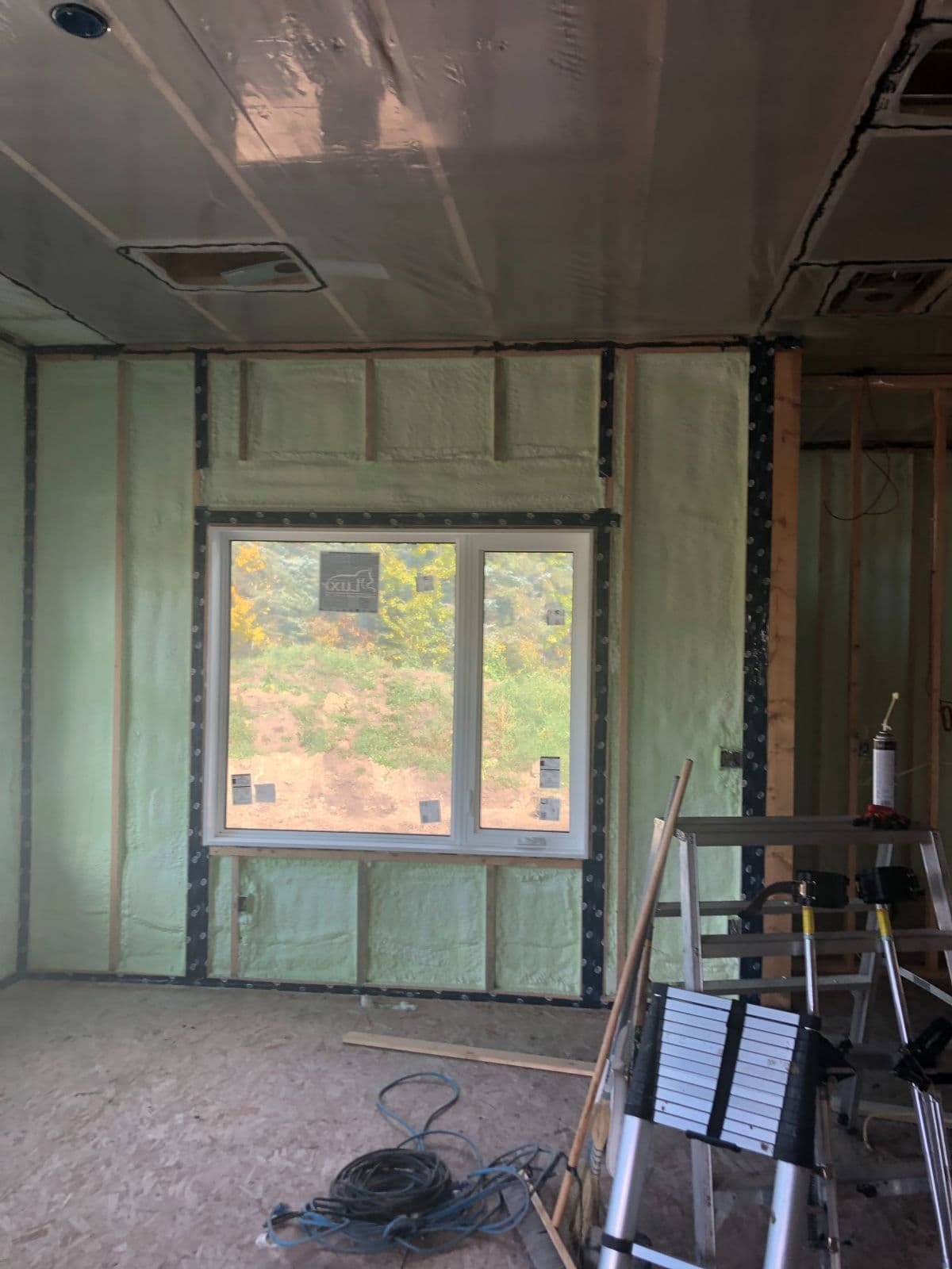 Spray foam in an exterior wall Exterior wall with green spray foam between the studs around a window